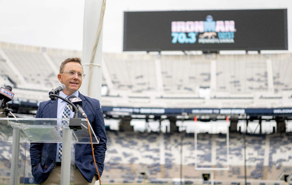 Drew Wolff, regional director for The Ironman Group, helps announce the Ironman 70.3 Happy Valley Triathlon on Thursday at Beaver Stadium. Competitors will finish the race July 2, 2023 in the stadium.