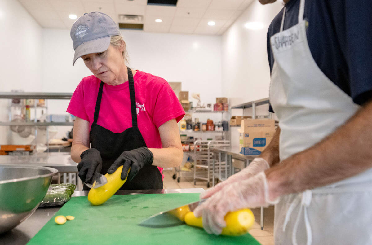 Sharon Schafer demonstrates how squash should be sliced at Taproot Kitchen on Thursday, August 1, 2024.