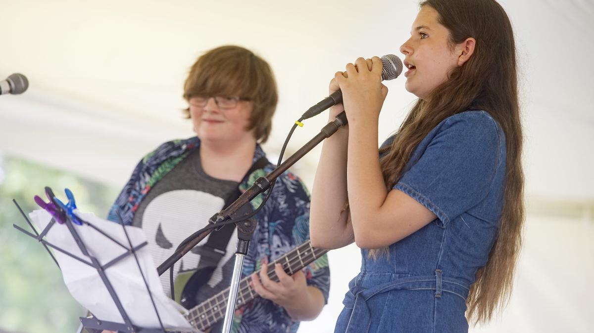 Hannah Crews, 12, sings with “Universal Distortion” from State College Rock Camp at the People’s Choice Festival on Friday, July 13, 2018.