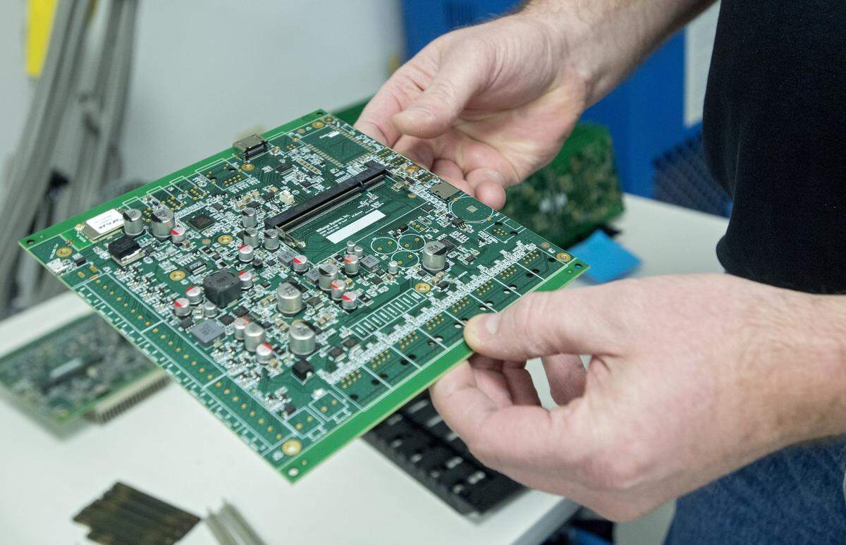 John Bonislawski of Homeland Manufacturing Services Inc. shows one of the company’s circuit boards in January.