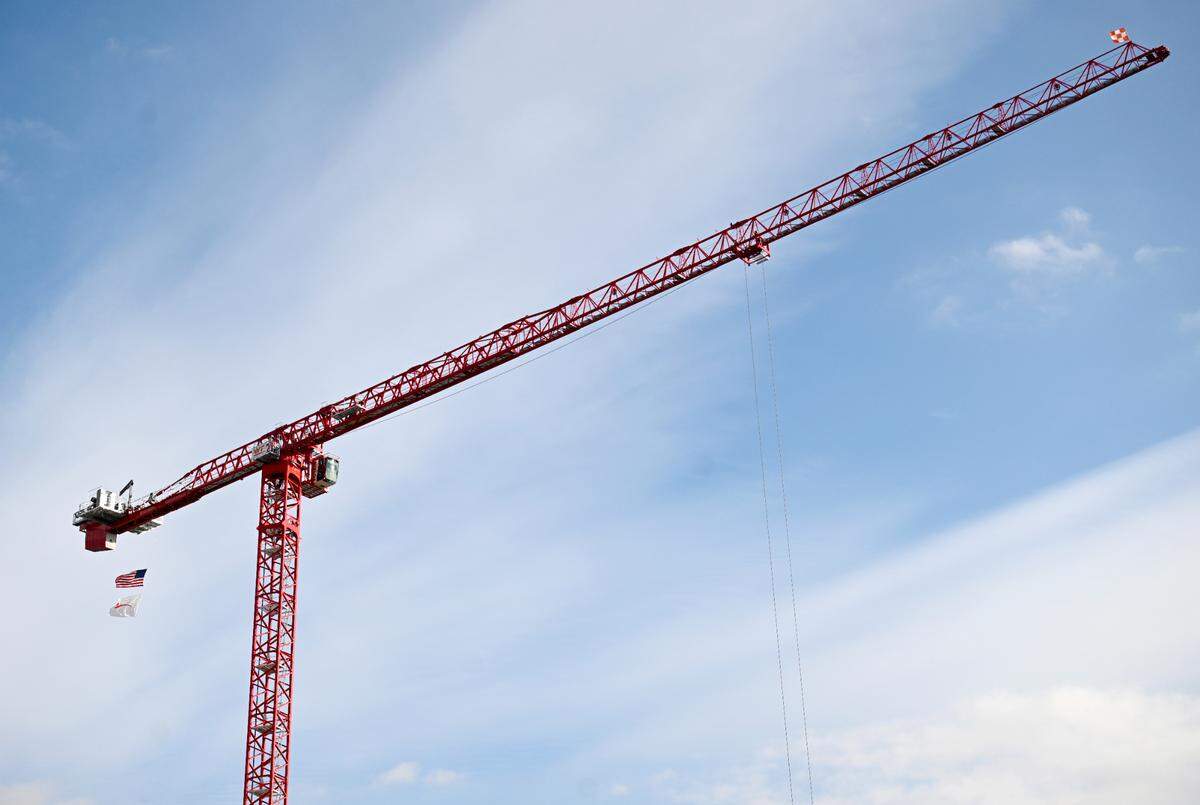 An American flag and a Mount Nittany Health logo flag hang from the large crane that will assist in building the new 10-floor patient tower.