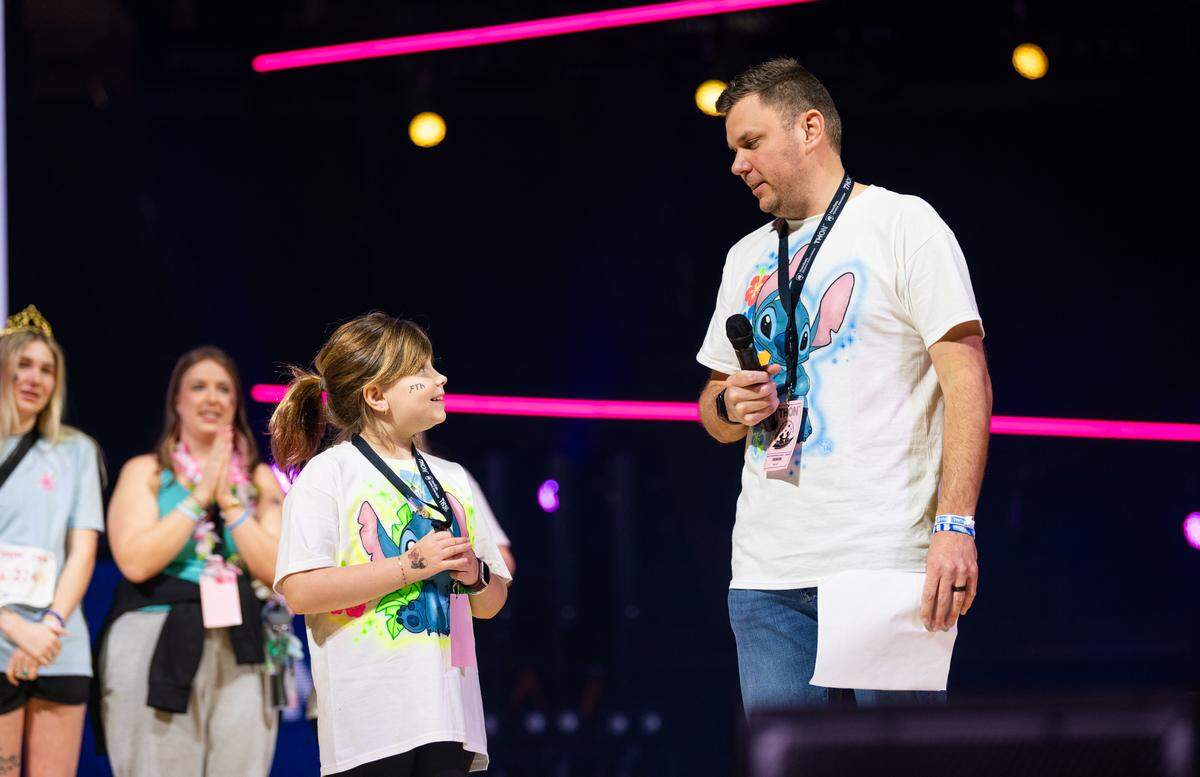 Four Diamonds child Keaghan Faulders, left, exchanges smiles with her father while speaking to the crowd at Thon in the Bryce Jordan Center on Sunday, Feb. 22, 2026.