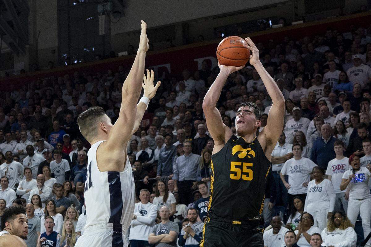 Iowa’s Luka Garza, right, shoots the ball with Penn State’s John Harrar, left, defending during the second half of an NCAA college basketball game Saturday in Philadelphia.