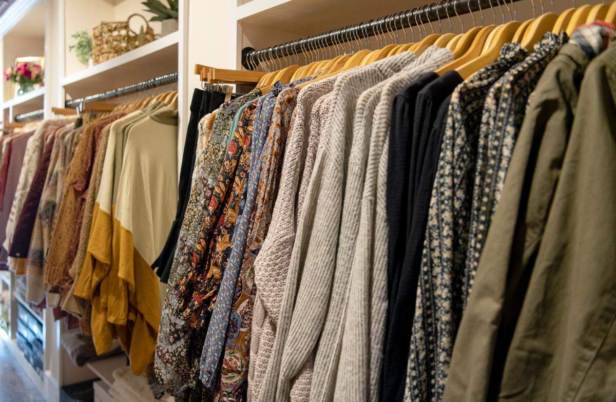 Sweaters and blouses are hung up at the newly opened By A Thread, a women’s clothing boutique on High Street in Bellefonte.