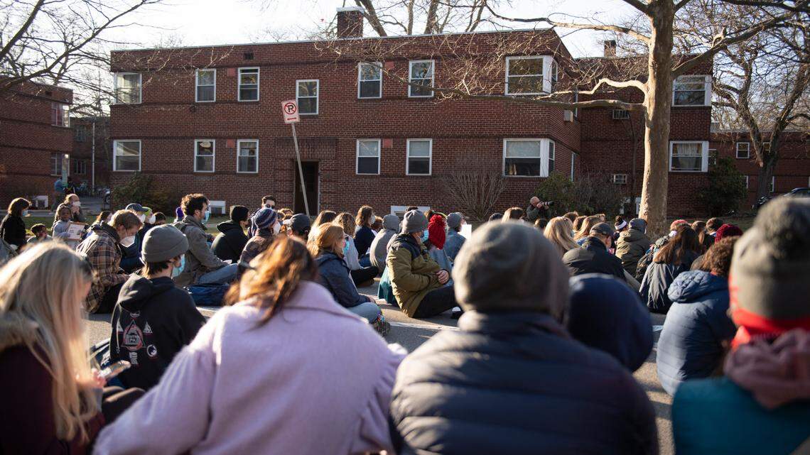 Protesters sit during a March 2021 protest march led by the 3/20 Coalition in front the apartment where Osaze Osagie was fatally shot by a police officer in 2019.