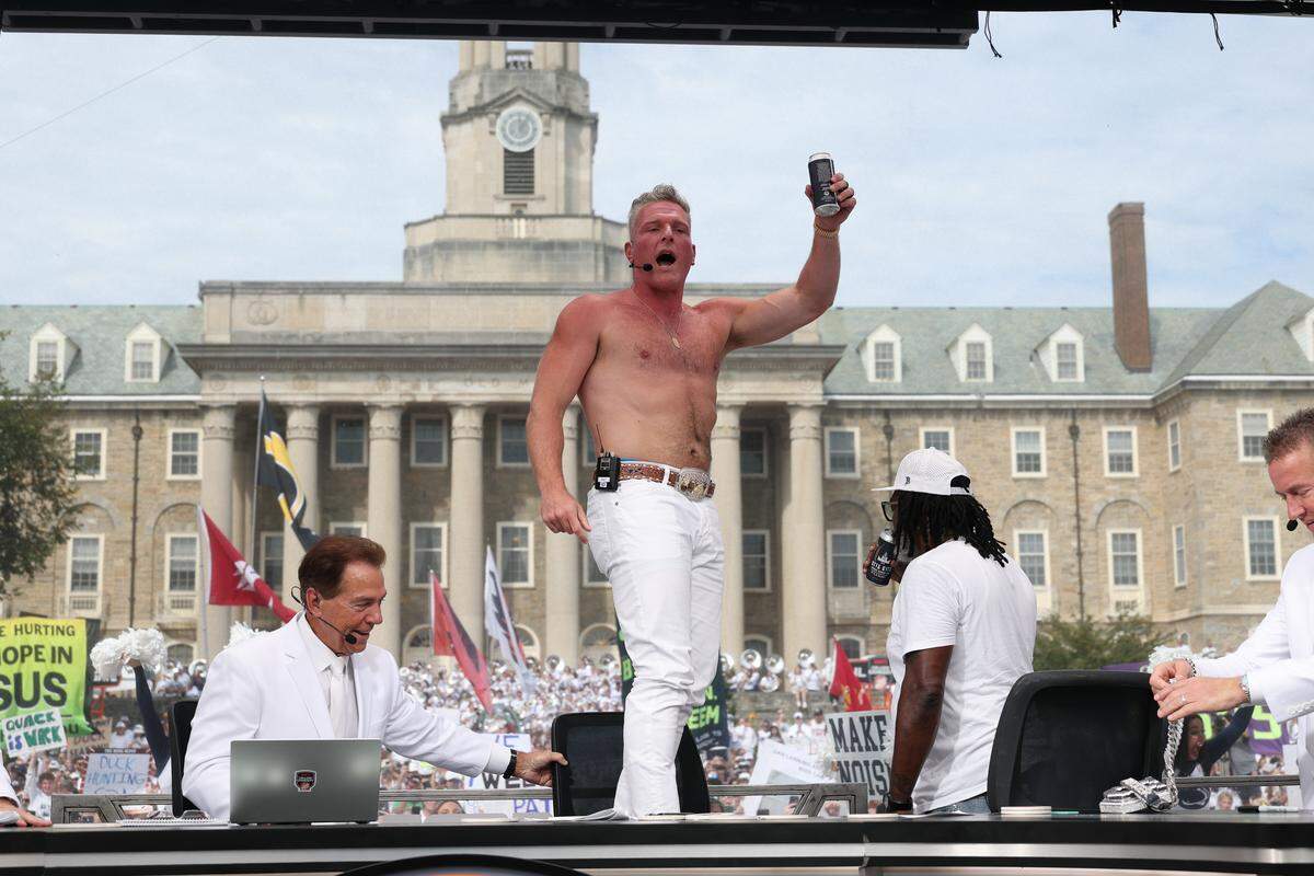 ESPN’s College GameDay analyst Pat McAfee takes off his shirt and cracks open a beverage after picking the Nittany Lions to beat Oregon on Saturday at the set of College GameDay on the lawn of Old Main at Penn State.