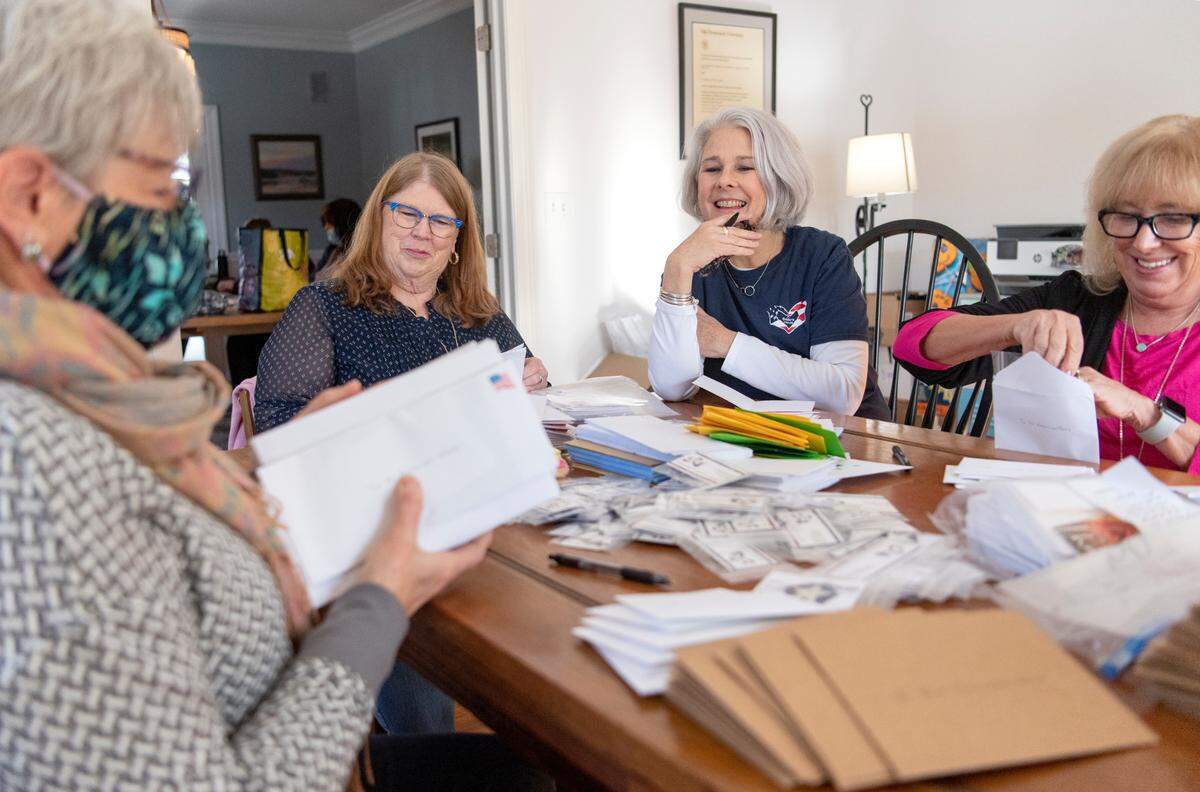 Trish Shallenberger, second from right, laughs with volunteers Wednesday as they put stars in cards to be sent to deployed military members through A Soldier’s Hands. They group is preparing to send 50,000 cards to Germany.