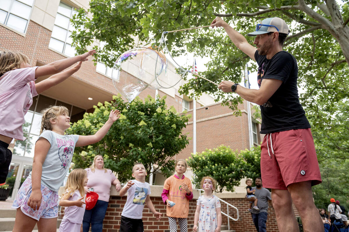 Paul Brigman makes large bubbles with a bubble wand made by his son at the Children and Youth Day sidewalk sale at the Central Pennsylvania Festival of the Arts on Wednesday, July 8, 2026.