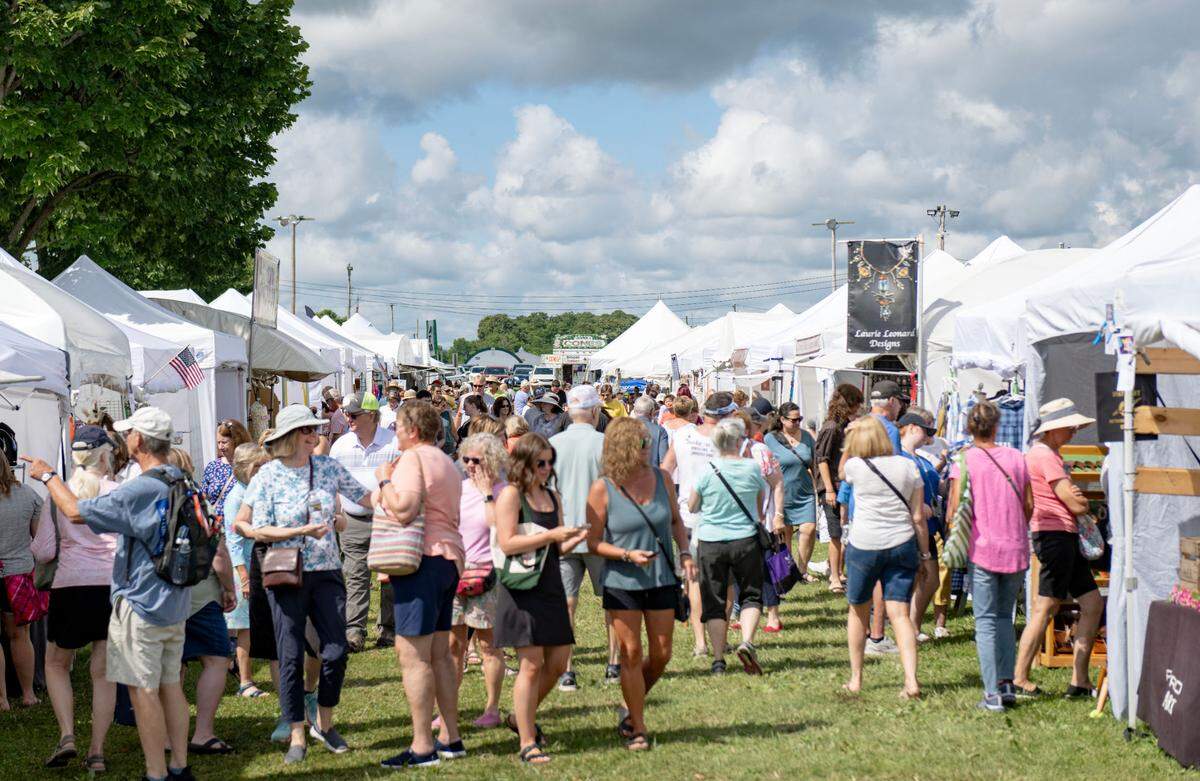 Visitors browse the booths at the People’s Choice Festival of Pennsylvania Arts & Crafts on Friday, July 12, 2024.