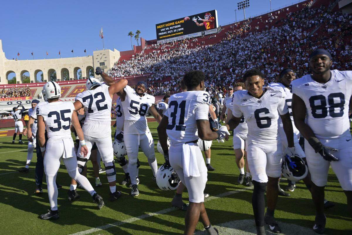 Oct 12, 2024; Los Angeles, California, USA; Penn State Nittany Lions players celebrate after defeating the USC Trojans in overtime at United Airlines Field at the Los Angeles Memorial Coliseum. Mandatory Credit: Jayne Kamin-Oncea-Imagn Images