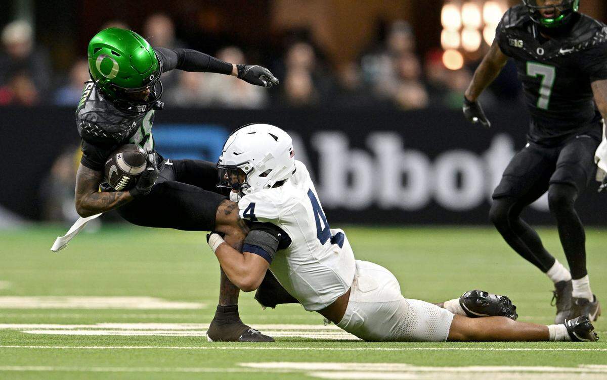 Penn State cornerback A.J. Harris trips up Oregon’s Tez Johnson during the Big Ten Championship game at Lucas Oil Stadium on Saturday, Dec. 7, 2024.