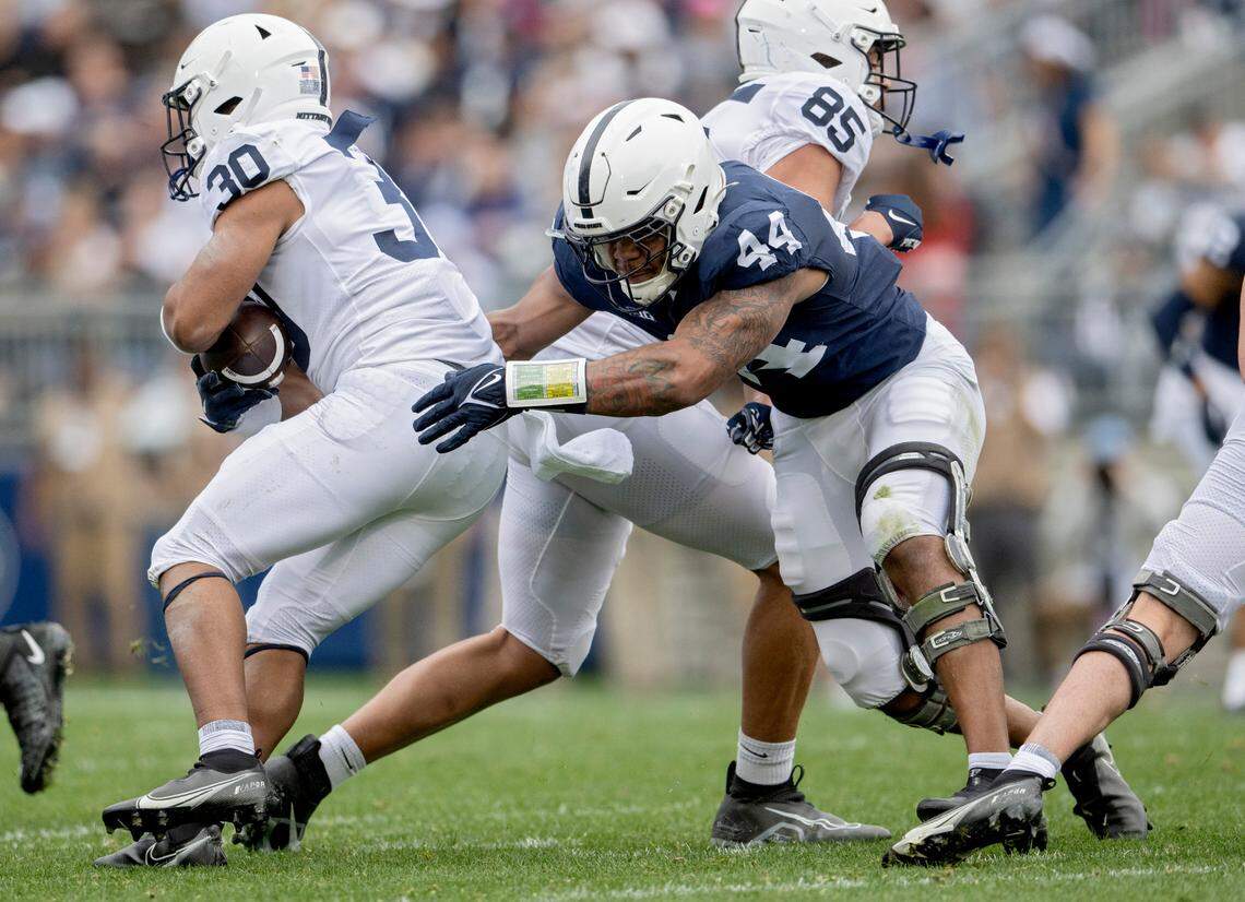 Defensive end Chop Robinson reaches for running back Amiel Davis during the Penn State Blue-White game on Saturday, April 15, 2023.
