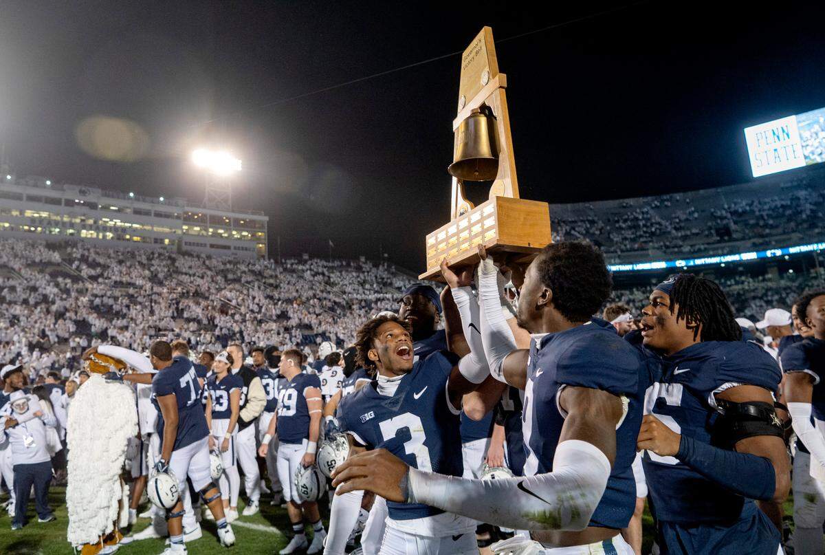 Penn State players hold up the Governor’s Victory Bell after the win over Minnesota on Saturday, Oct. 22, 2022.