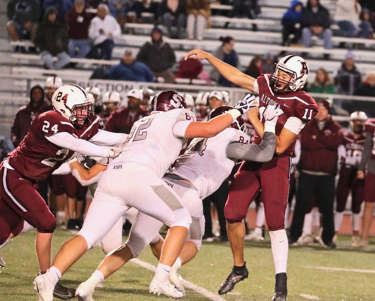 State College defensive linemen Sam Storll (62) and Nathan Lusk (84) pressure Altoona’s quarterback on Friday.