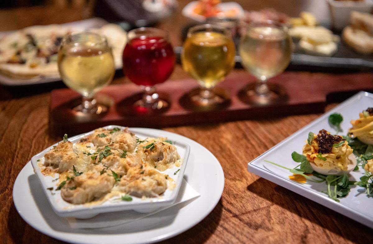 Small plates including French onion soup dumplings from Alloy Kitchen with a flight of Mad McIntosh Cider on Wednesday, April 13, 2022.