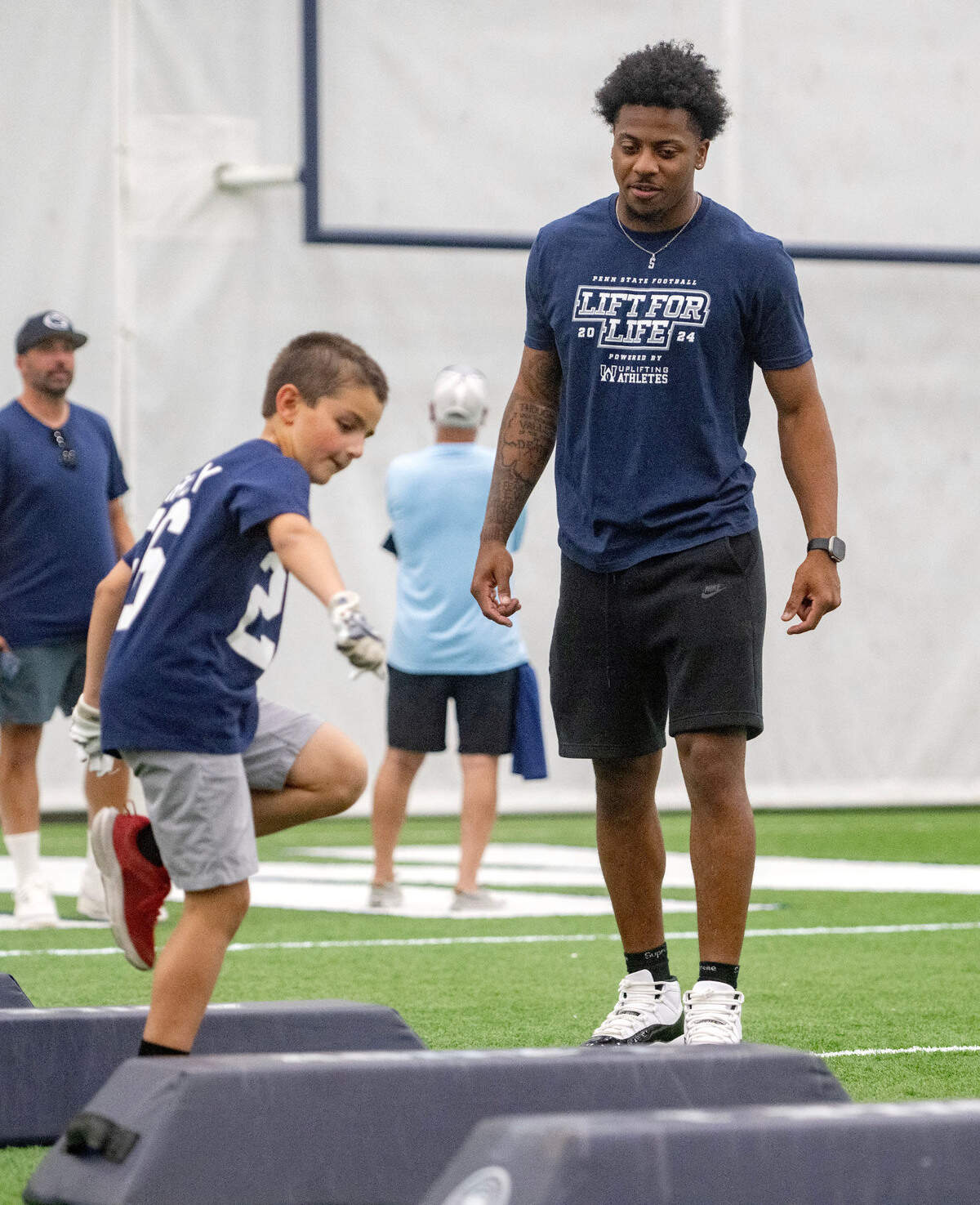 Penn State safety DaKaari Nelson watches a youngster run a drill as part of the kids clinic during the 21st Annual Lift for Life to benefit Uplifting Athletes on Thursday, June 13, 2024 in Holuba Hall.