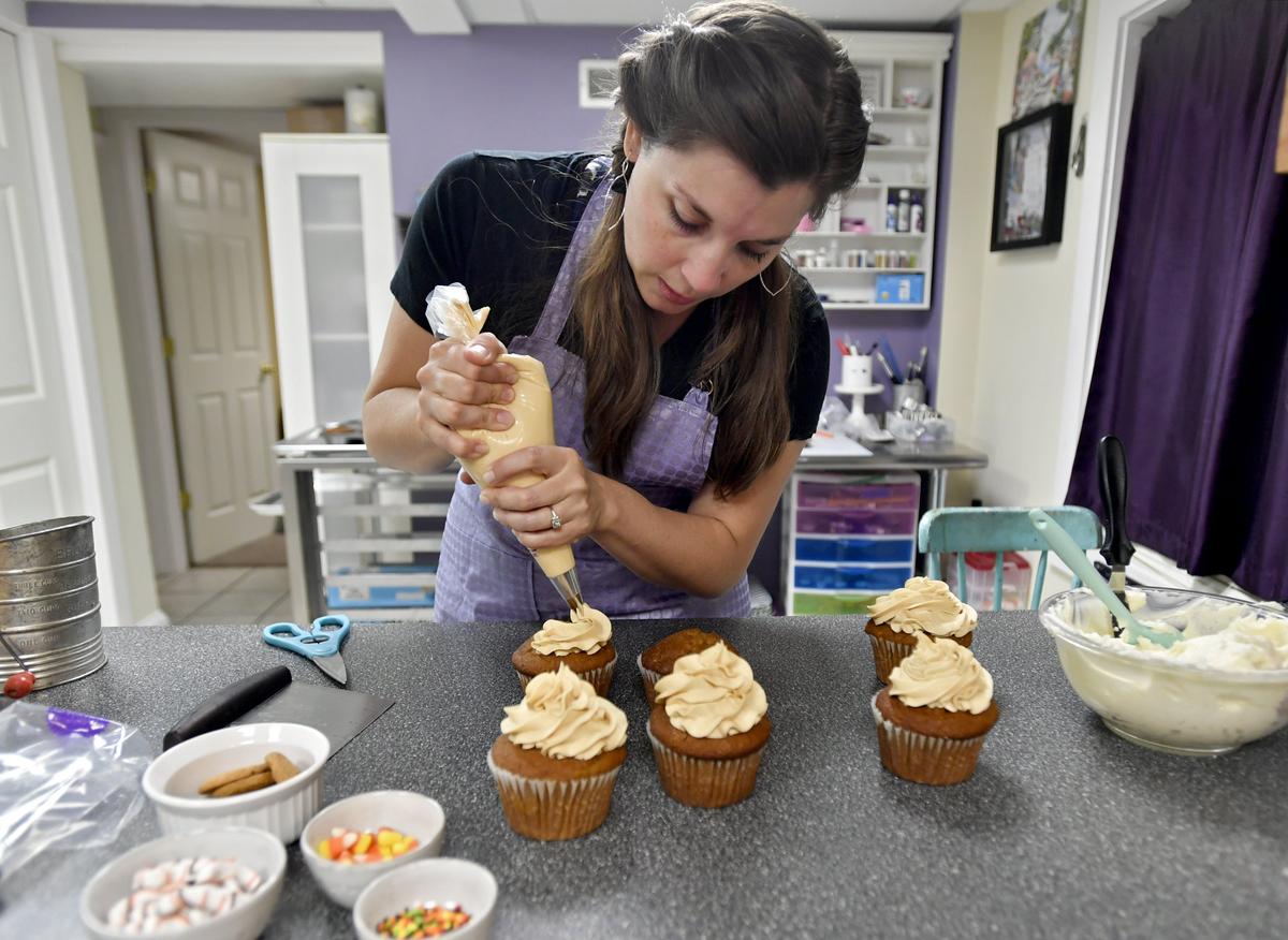 Melissa Stitzer of The Cakery uses salted caramel icing to frost pumpkin cupcakes that will be sold at the Red Horse Tavern on Wednesday, Sept. 26, 2018.
