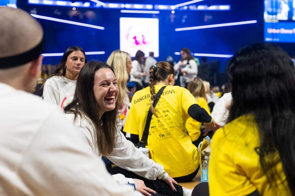 Dancer Natalie Korzuch, a senior studying supply chain and information systems, laughs during a conversation with fellow dancers before standing up for Thon on Friday, Feb. 20, 2026. Korzuch is a dancer for The Sapphire Leadership Academic Program.
