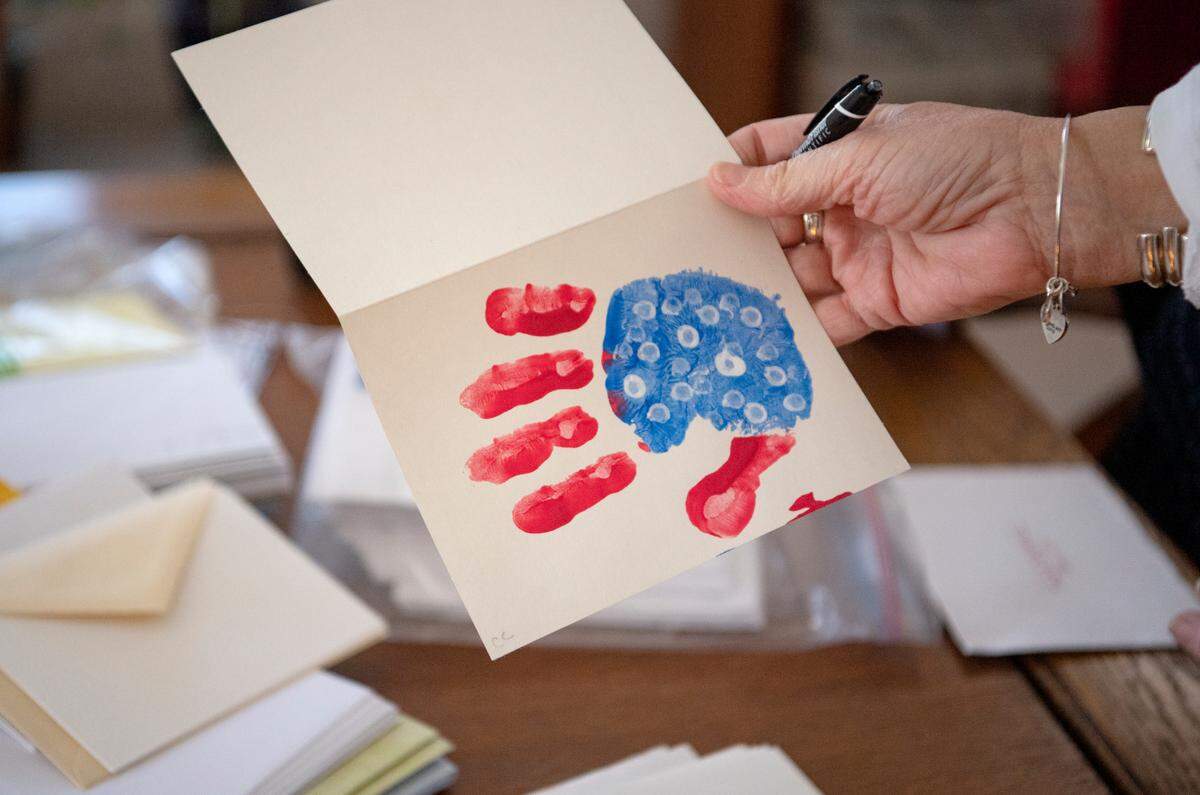 Trish Shallenberger admires a card made from a class of students to be sent to deployed military members through the nonprofit she founded, A Soldier’s Hands.