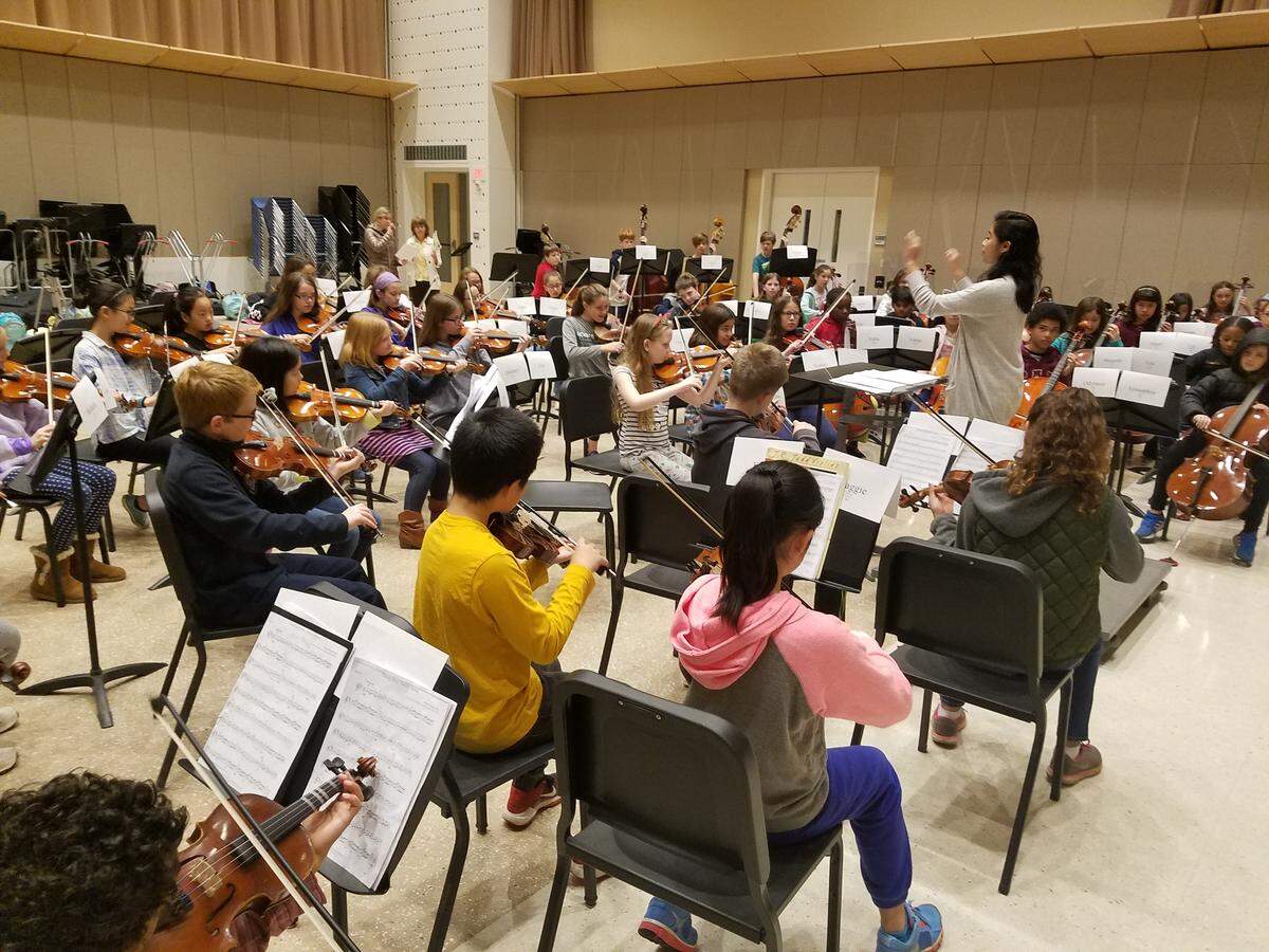 The string orchestra is led by Penn State senior music education major Anna Miller Wednesday morning as it rehearses in Esber Rehearsal Room at the Penn State School of Music for the upcoming Partners in Music concert. The orchestra includes more than 60 fifth grade string players from local elementary schools.