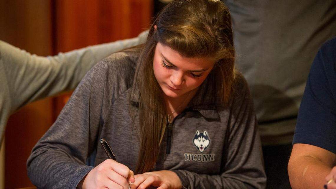 Kyla Irwin signs her National Letter of Intent to play basketball at UConn early Wednesday morning at her home in Lemont. 
