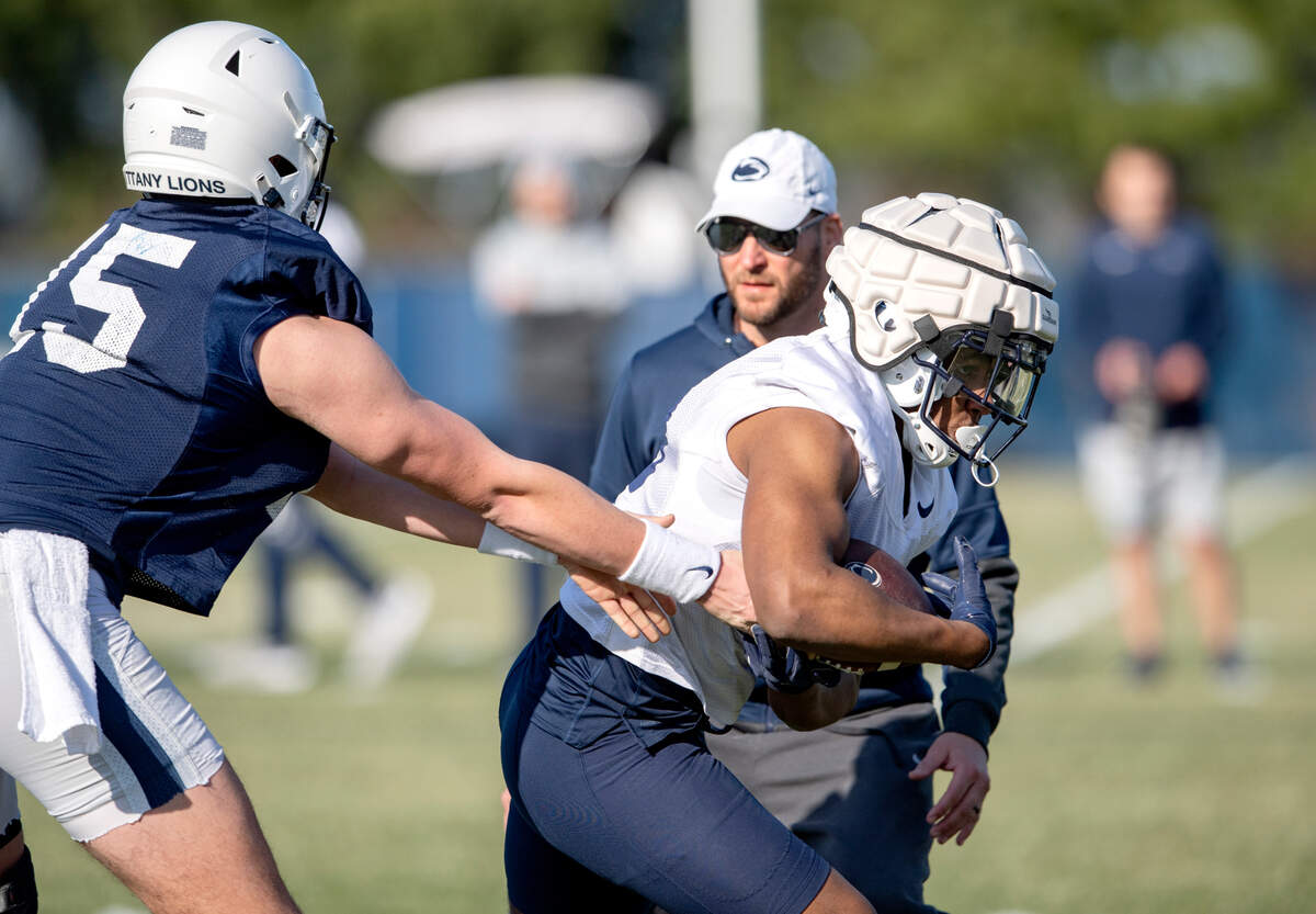 Penn State quarterback Drew Allar hands the ball to running back Nicholas Singleton during the first day of spring practice on Monday, March 21, 2022.