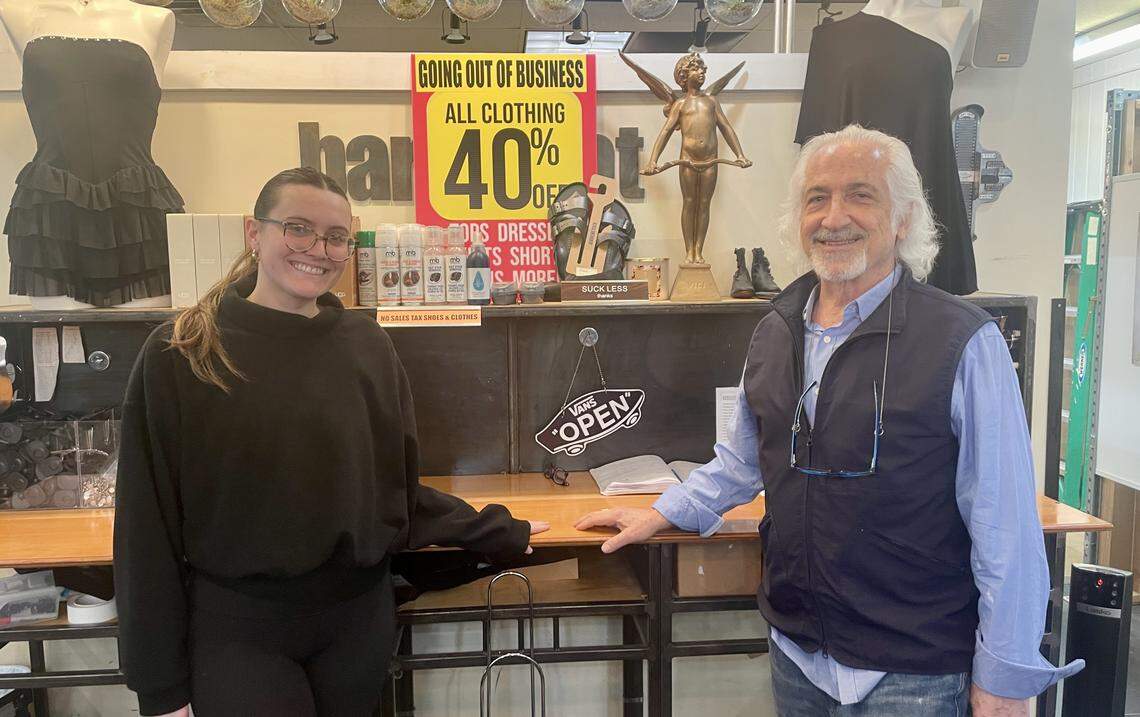 Barefoot owner Art Fine poses with an employee, Lily, as his store runs heavy discounts before closing in May.