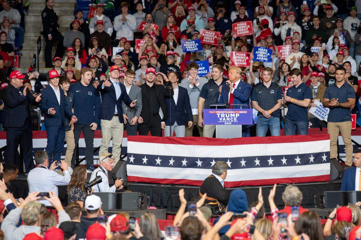 Donald Trump welcomes members and former members of the Penn State wrestling team on stage during a rally for his presidential campaign at the Bryce Jordan Center on Saturday, Oct. 26, 2024.
