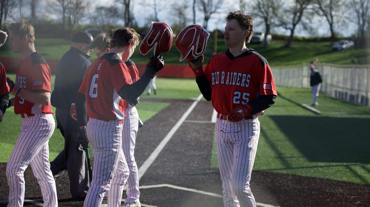 Bellefonte senior Quentin Crouthamel (25) taps his helmet with teammate junior Cole Houser (6) after a run during a game against Tyrone in Bellefonte, Pa., on Monday, April. 6, 2028. The Red Raiders beat the Golden Eagles 6-0.