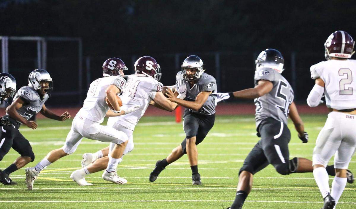 State College’s Nathan Lusk (84) blocks for Conrad Moore (9) as he runs down the field against Central Dauphin East on Friday. State College won 48-7.