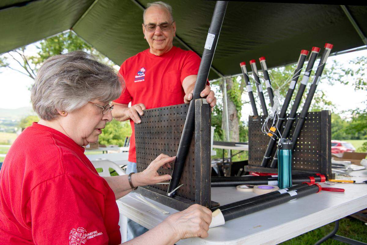 Pyrotechnic volunteers work together on rigging firework candles on Thursday, June 27, 2019 for the Central PA 4th Fest fireworks show.