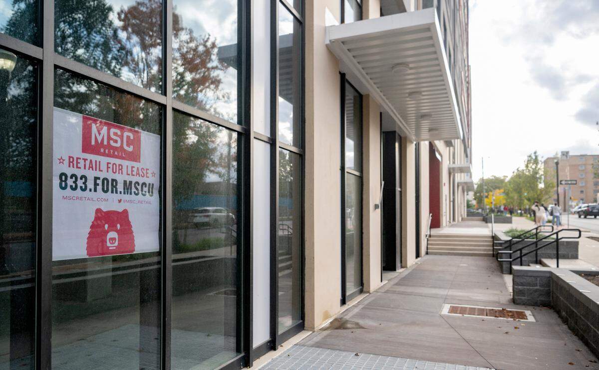 Signs for spaces for lease are in the windows of the empty storefronts at The Standard on the corner of West College Avenue and Atherton Street.