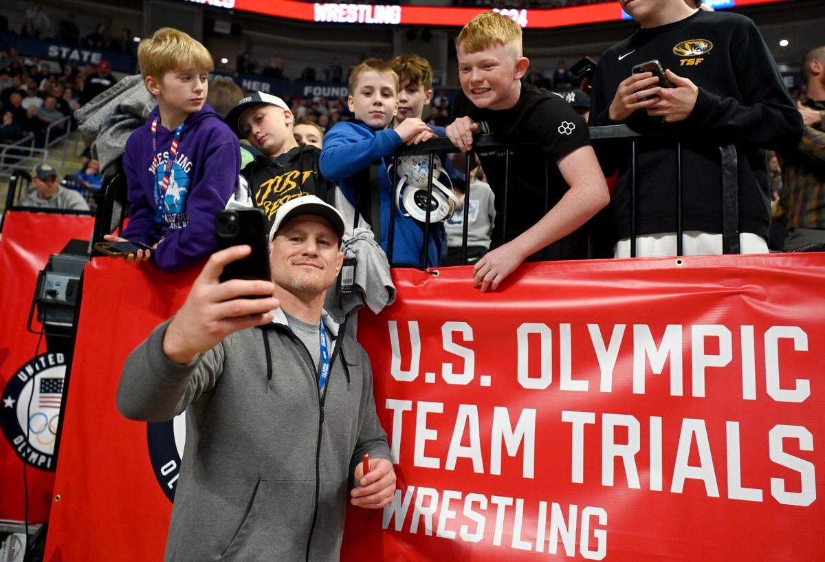 Cael Sanderson stops to take a selfie and sign autographs with young fans during the U.S. Olympic Team Trials at the Bryce Jordan Center on Friday, April 19, 2024.