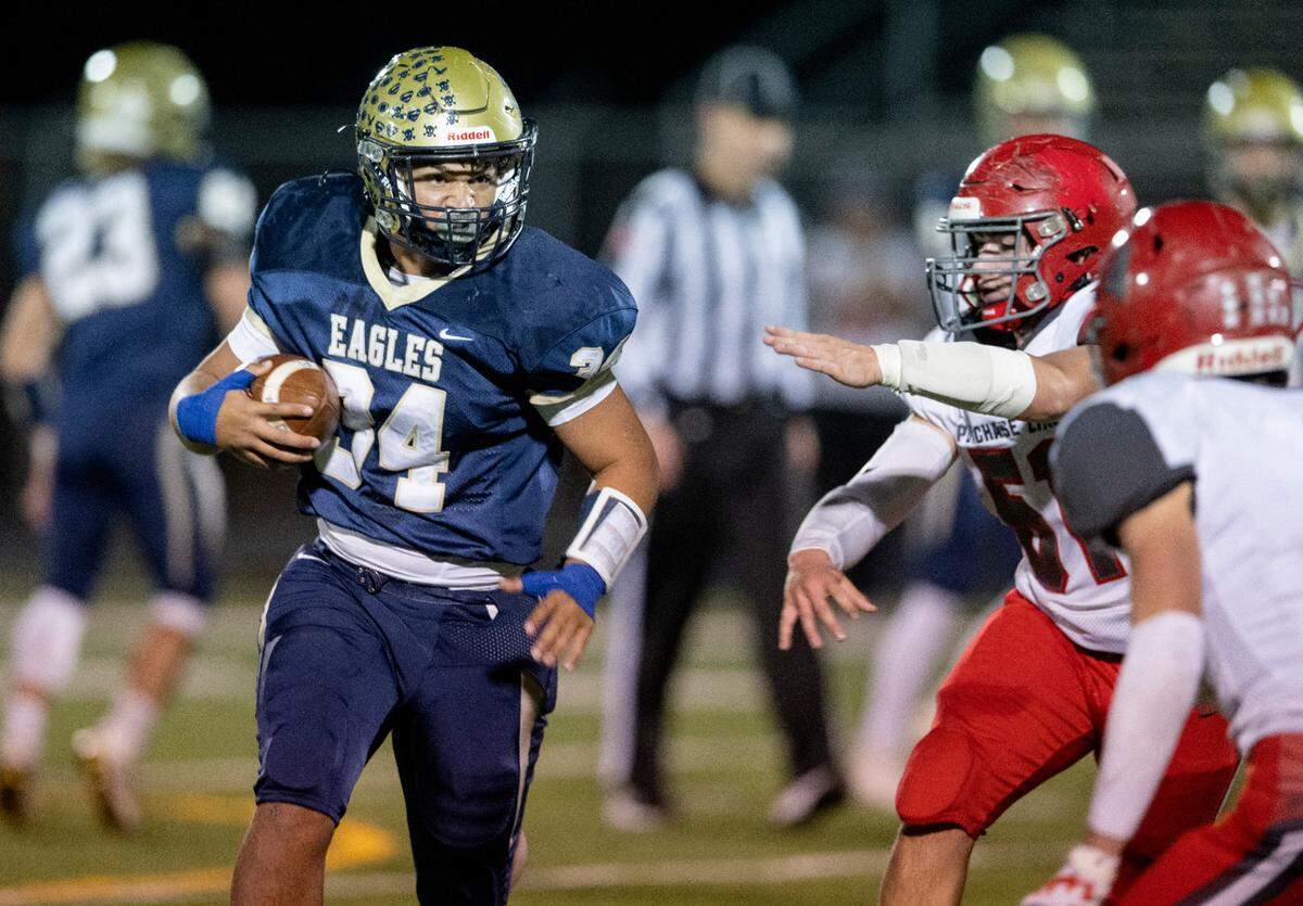 Bald Eagle Area’s Tre Greene runs down the field with the ball around Purchase Line defenders during the game on Friday, Oct. 28, 2022.