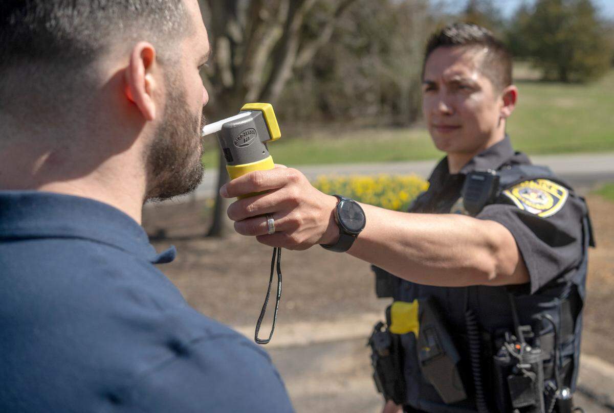 Spring Township police officer Chris Snare and intern Evan Gelman demonstrate a breathalyzer test.