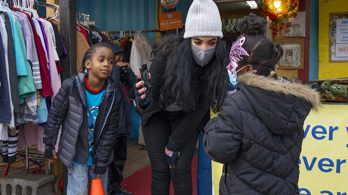 Gisele Fetterman helps out Jvyair Payton and Amia Clark at the Free Store, letting Amia see how she looks in a mask.