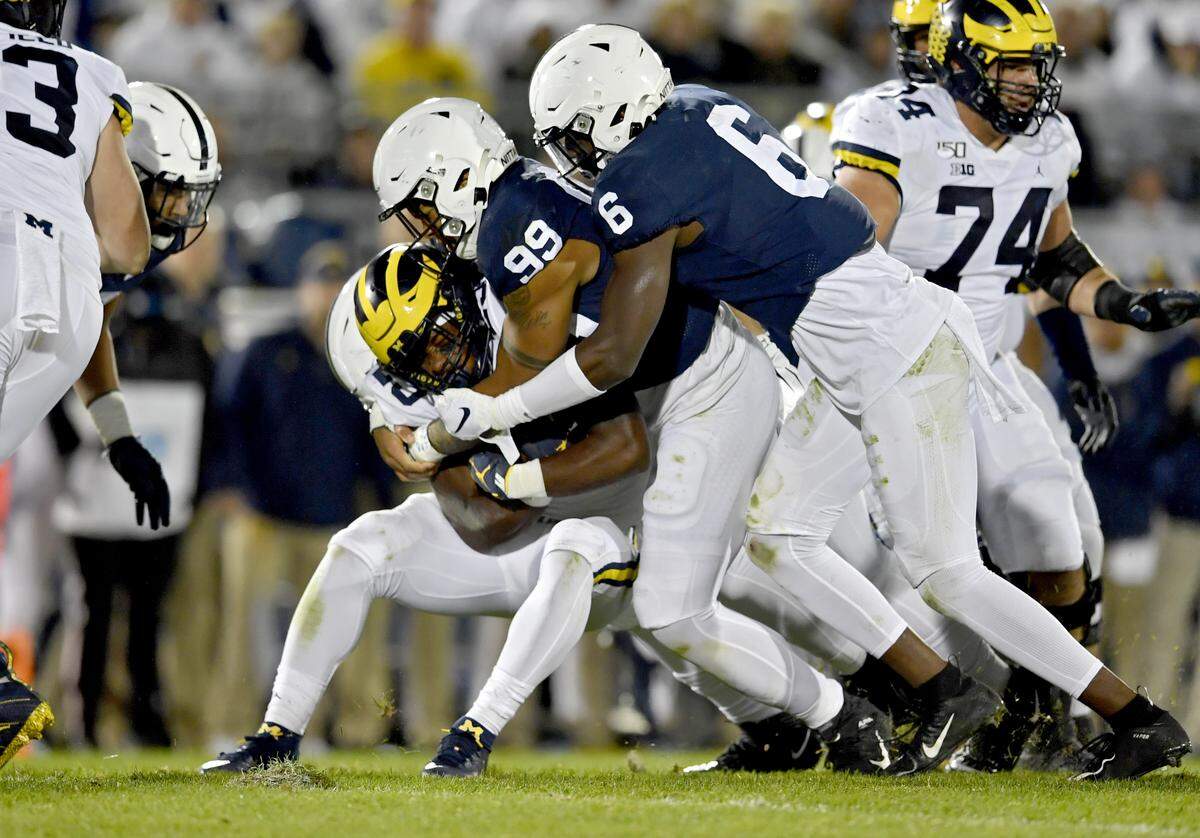 Penn State defensive end Yetur Gross-Matos and linebacker Cam Brown stop Michigan’s ball carrier during the game on Saturday, Oct. 19, 2019.
