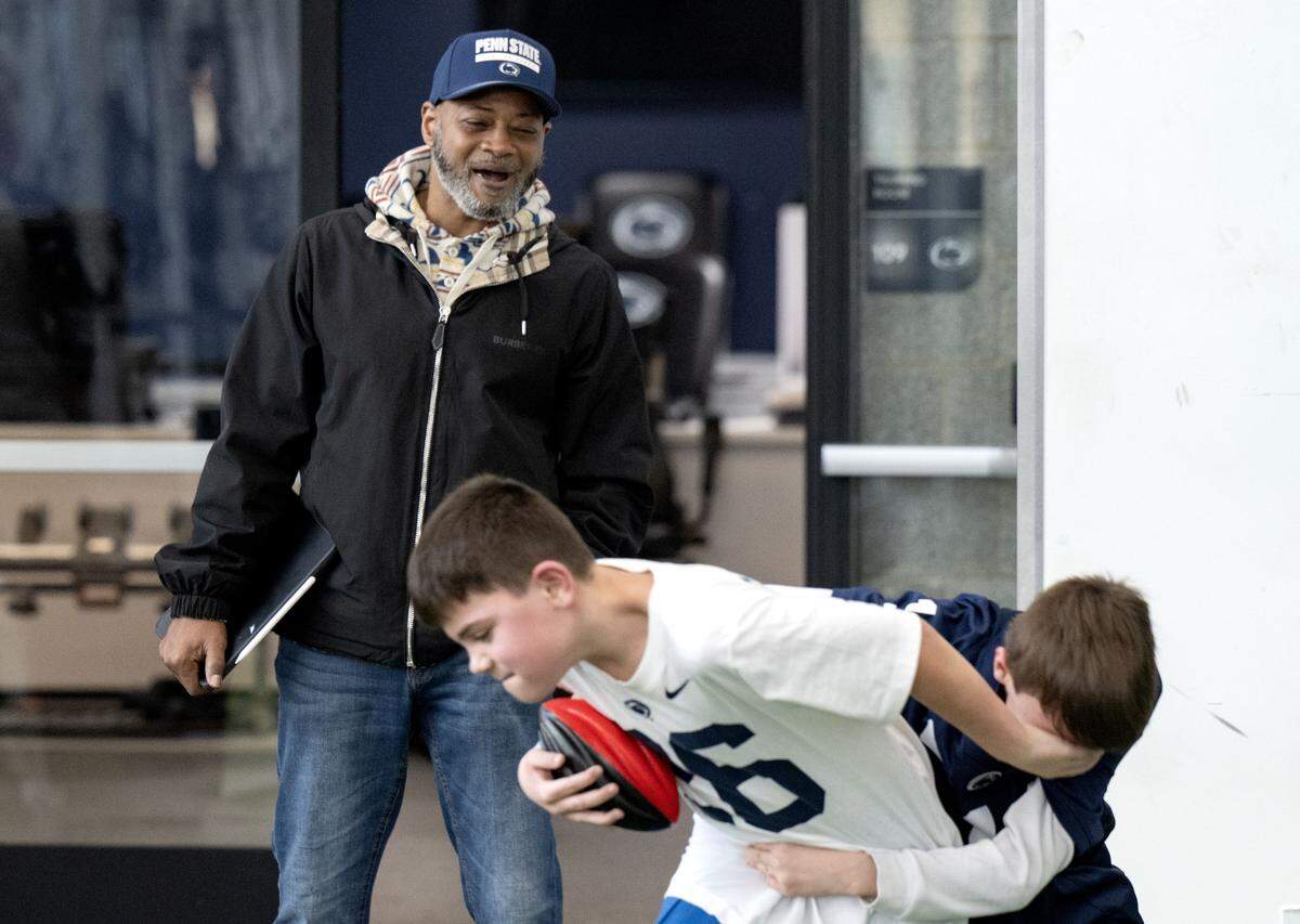 Assistant coach Terry Smith yells to Harrison and Hudson Fischman as they play football during the Thon Explorers event at the Lasch Building on Saturday, Feb. 21, 2026.  
