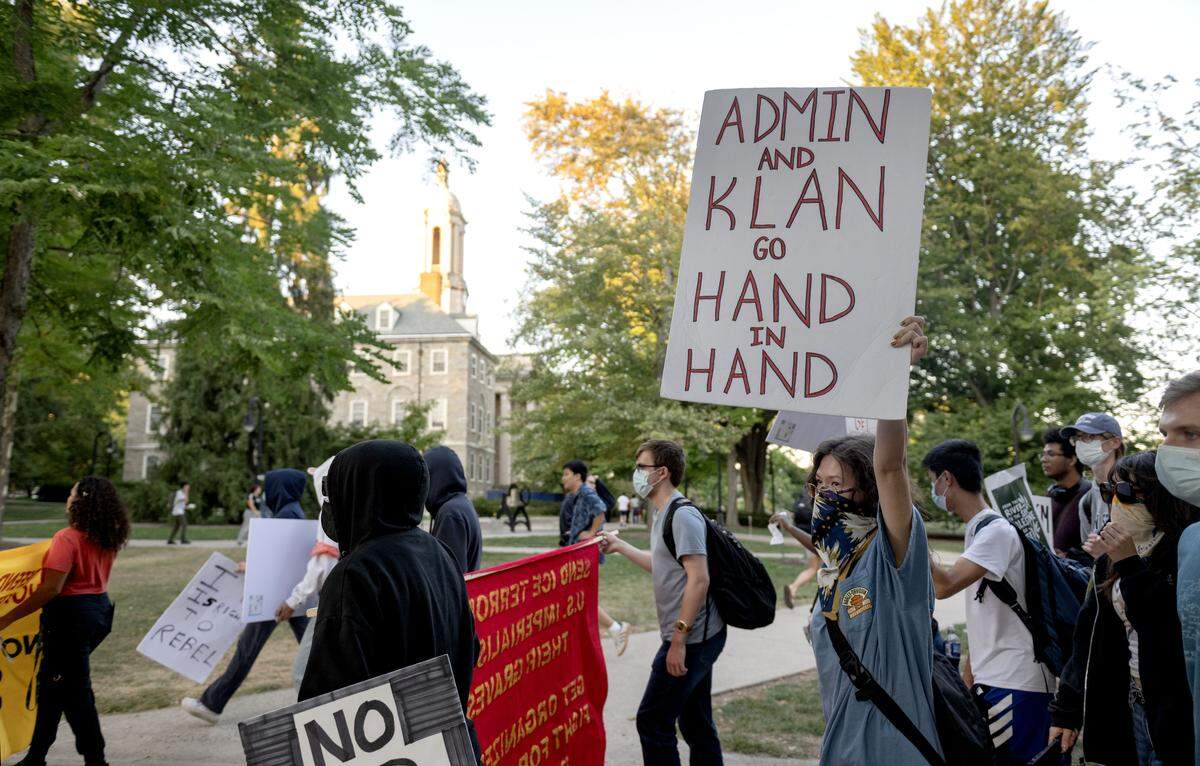 A crowd walks through the Penn State campus and past Old Main as part of an anti-ICE protest on Thursday, Sept. 11, 2025.  