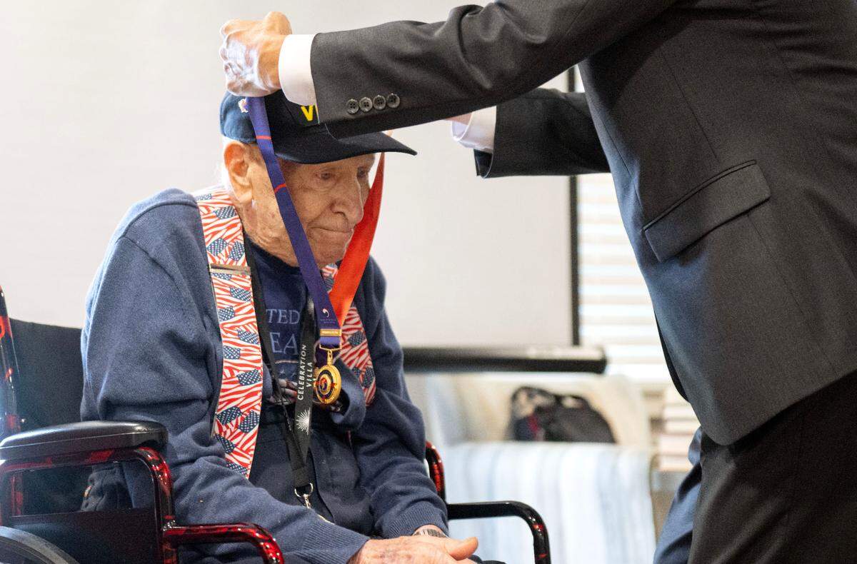 Bruce Berkey is emotional as he is presented an Ambassador of Peace Medal for a friend of his who was killed in the Korean War. A ceremony was held Friday at Celebration Villa of Nittany Valley.