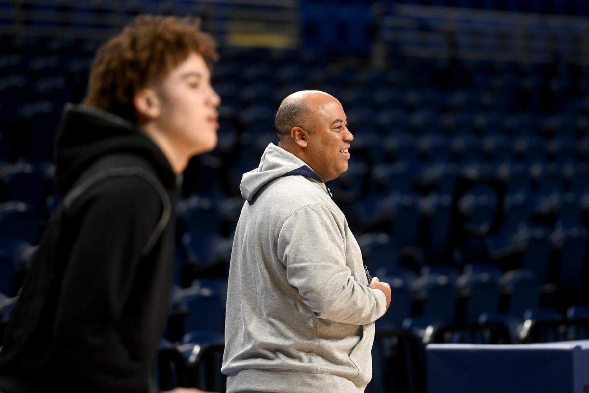 Penn State men’s basketball coach Micah Shrewsberry walks on the court with his son, Braeden, as his shoots around during media day on Tuesday, Oct. 25, 2022.