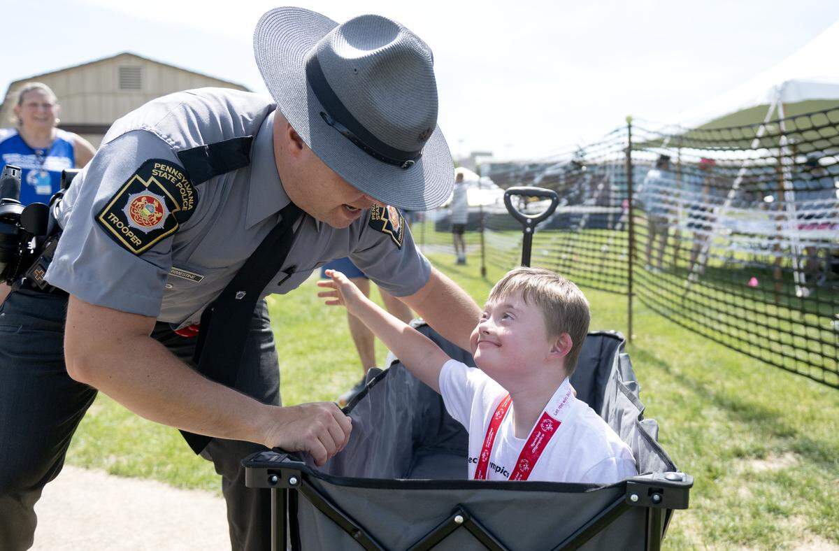 William DeVallance from Fayette County reaches to hug Pennsylvania State Trooper Jacob Rhymestine after he received his medal at the 2026 Special Olympics Pennsylvania Summer Games on Thursday, June 4, 2026. 