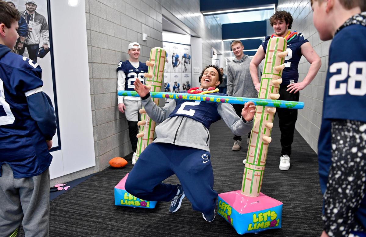 Penn State cornerback Keaton Ellis laughs as he tries to do the limbo with with Four Diamond families in the Lasch Building on Saturday, Feb. 22, 2020.