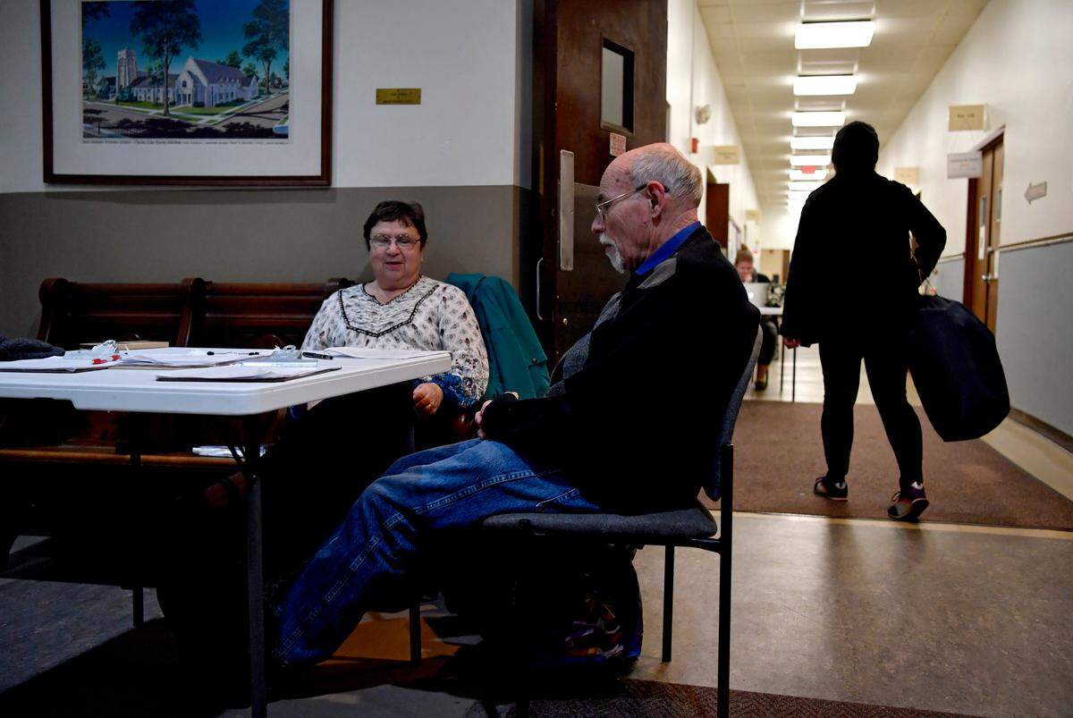 Volunteers check guests in to the Out of the Cold shelter at St. Andrew’s Episcopal Church on Nov. 26.