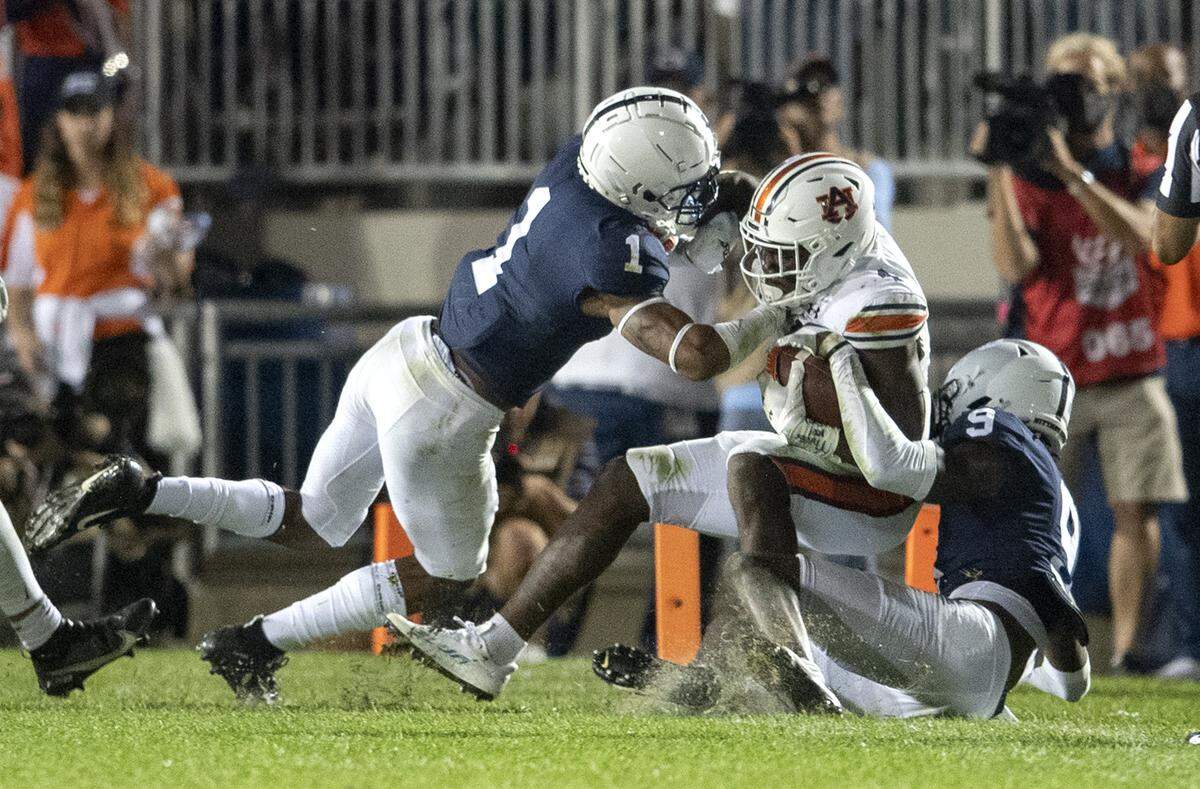 Penn State safety Jaquan Brisker and cornerback Joey Porter Jr. stop Auburn’s ball carrier during the game against Auburn on Saturday, Sept. 18, 2021.
