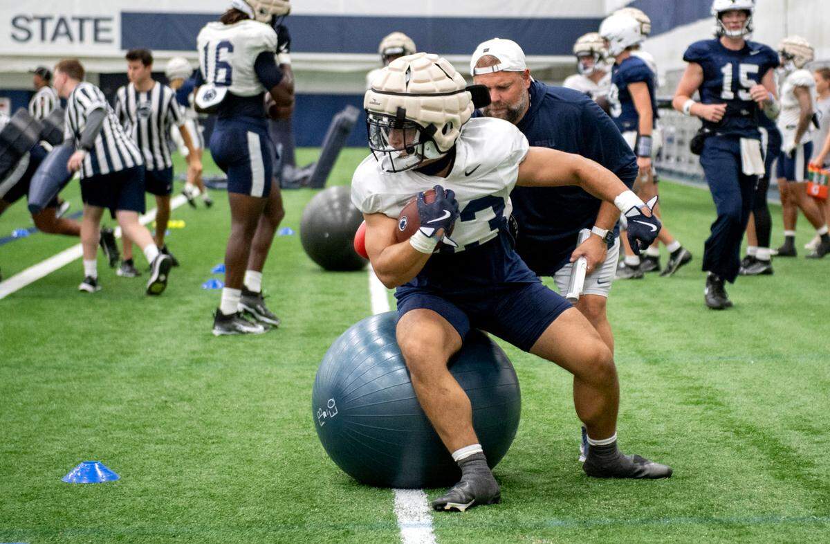 Penn State wide receiver Jake Spencer runs a drill with offensive coordinator Andy Kotelnicki during practice on Saturday, Aug. 3, 2024.