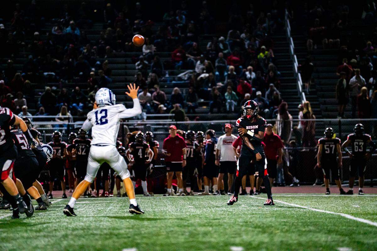 Clearfield senior Xavier Curry (1), right, throws a pass above Penns Valley linebacker Cael Smith (12) during a Friday night football game between Clearfield and Penns Valley in Clearfield, Pa., on Sept. 26, 2025. The Bison beat the Rams 46-14.