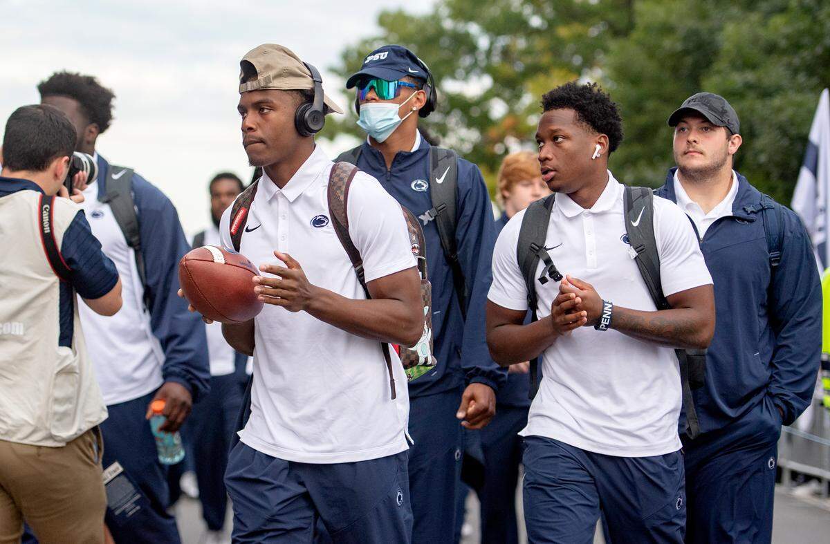 Penn State wide receiver Jahan Dotson tosses a ball between his hands as he arrives with the team.