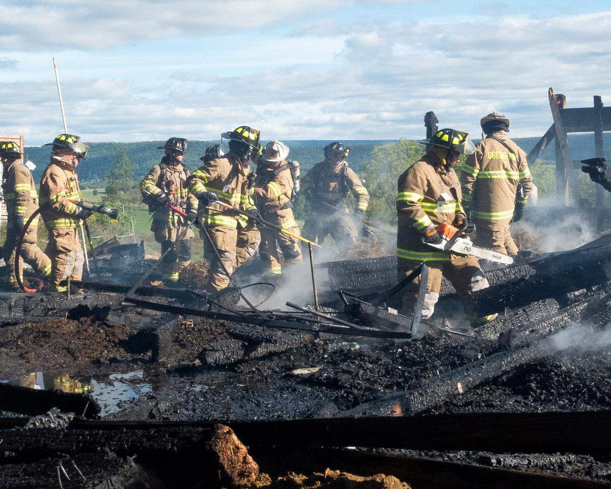 A large group of Millheim firefighters look for hot spots to make sure the fire is out at a barn fire on Paso Lane on Thursday, Sept. 29, 2022.
