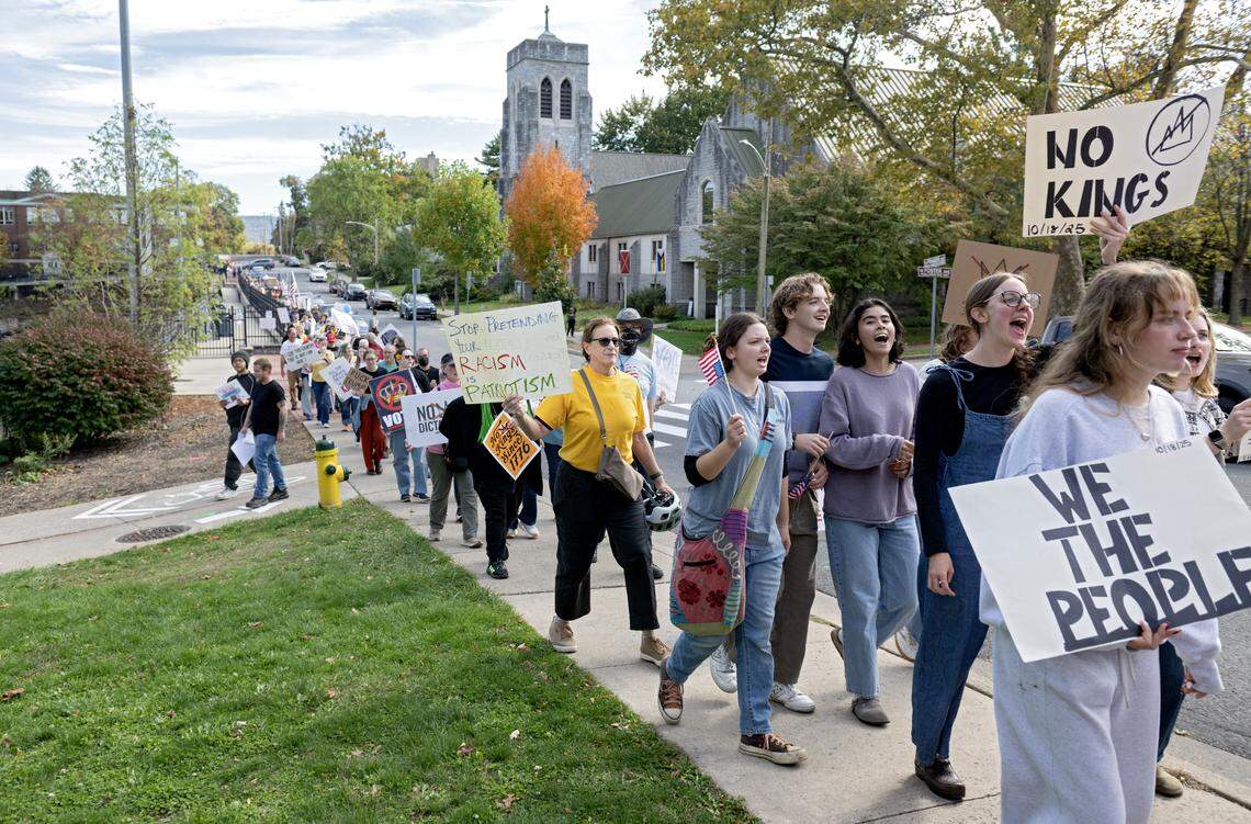 Protesters marched on the sidewalks along Fraser Street as part of the No Kings anti-Trump rally on Saturday, Oct. 18, 2025. 